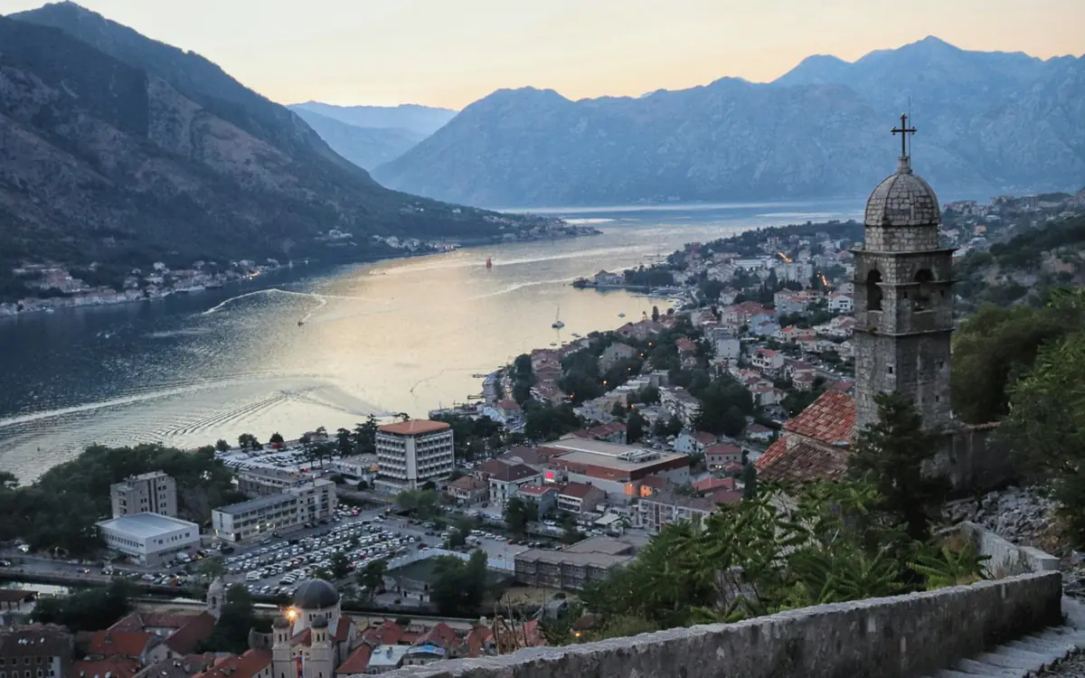 Kotor Old Town and the Bay of Kotor viewed from above, with mountains behind.