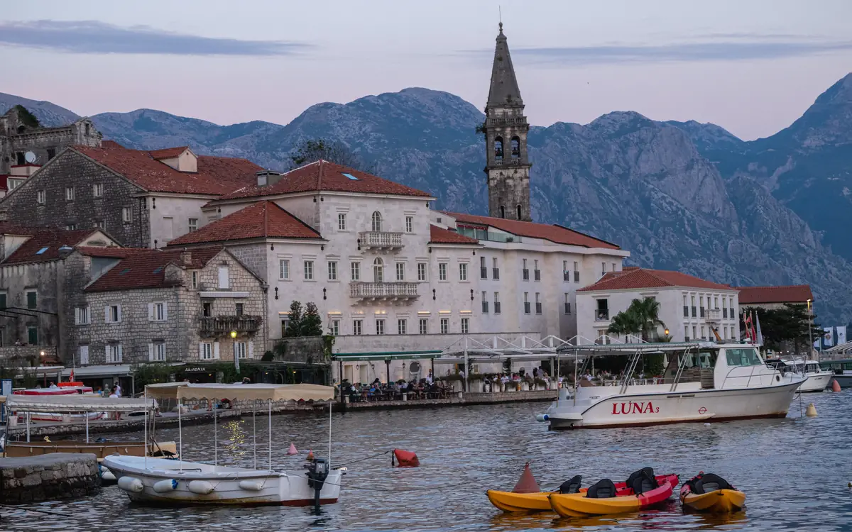 Perast waterfront and St. Nicholas Church bell tower beside the Bay of Kotor.
