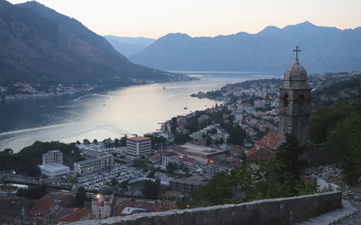 Kotor Old Town beside the Bay of Kotor below steep mountains.
