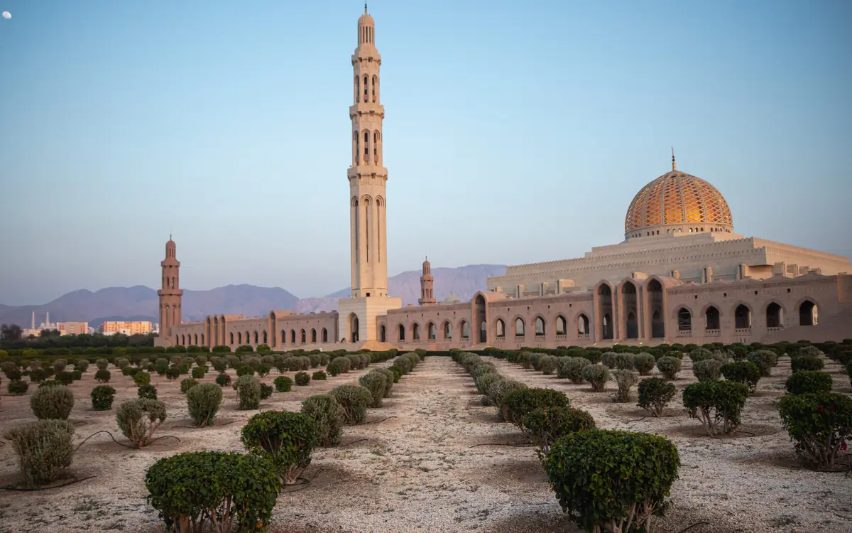 Sultan Qaboos Grand Mosque with a garden path and minaret.