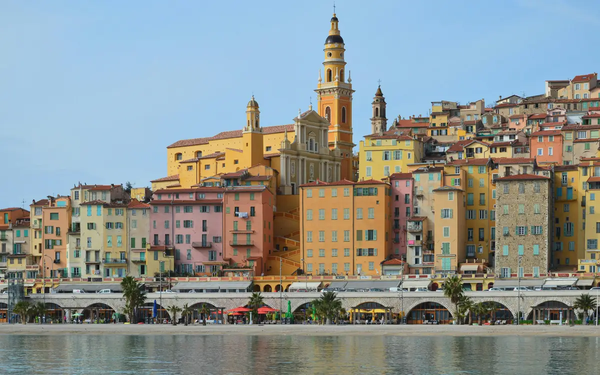 Pastel waterfront town with church tower at Basilique Saint-Michel-Archange.