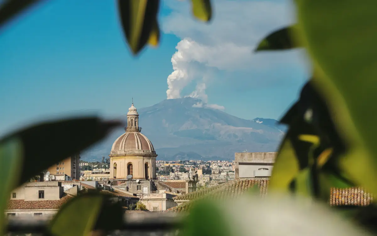 Church dome in Catania with Mount Etna behind it.
