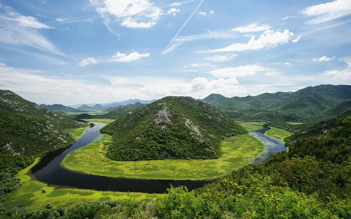 Horseshoe river bend through green wetlands in the Lake Skadar landscape.