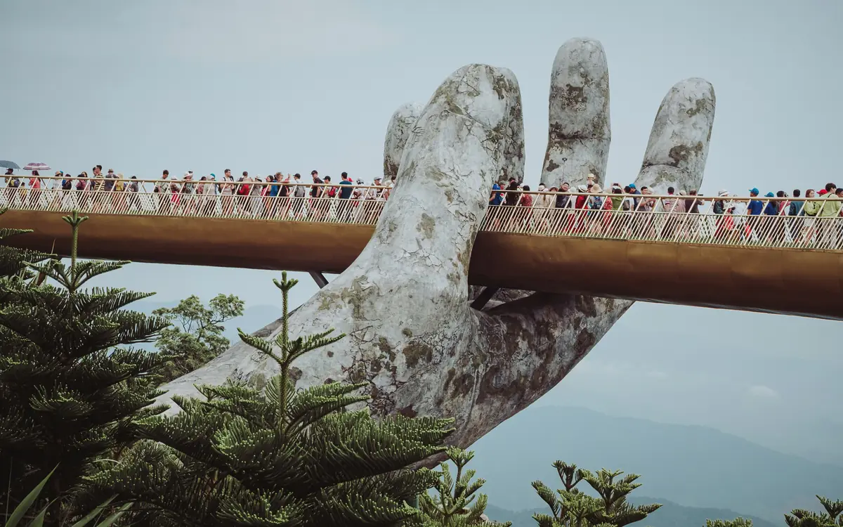 Golden Bridge held by giant stone hands.