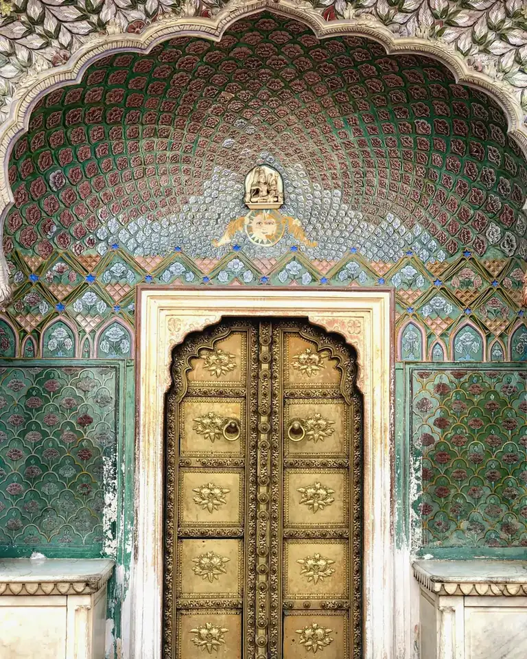 Ornate decorated doorway with an arched niche and painted or tiled architectural detail in India.